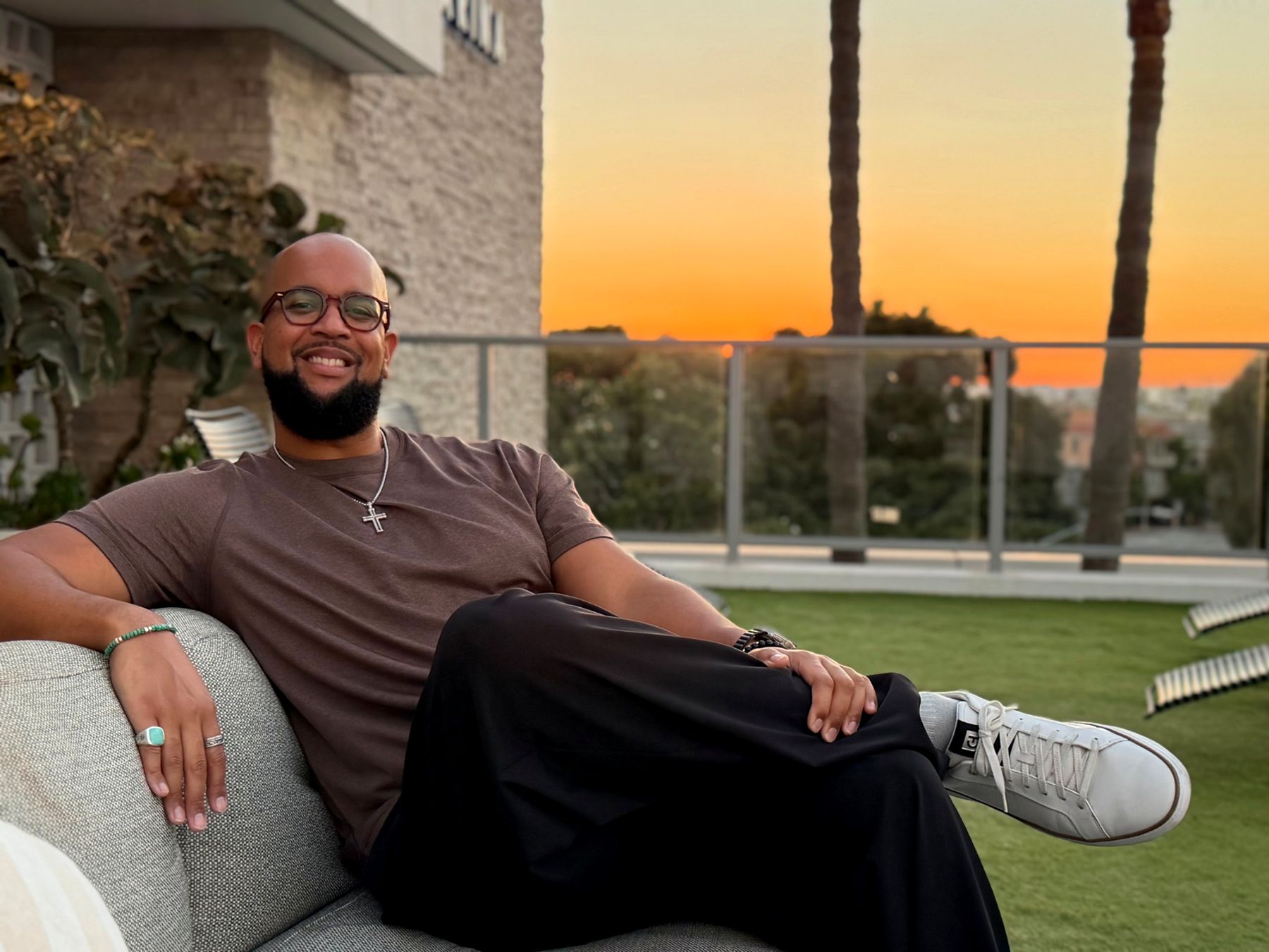 Joseph Street relaxing on a rooftop terrace at sunset
